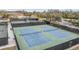 Well-maintained tennis courts are surrounded by fences, lush greenery, a pond, and fountains at 2769 St Andrews Blvd, Tarpon Springs, FL 34688