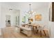 Bright dining room features modern chandelier, light wood floors, and a bench seat for comfortable dining at 2814 Graphite Ct, Valrico, FL 33594