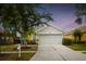 Charming one-story home with a well-manicured lawn and a two-car garage at dusk at 2814 Graphite Ct, Valrico, FL 33594