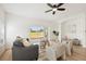 Bright living room with wood-look floors, neutral furniture, ceiling fan, and sliding glass doors to the backyard at 2814 Graphite Ct, Valrico, FL 33594