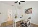 Bright home office with white desk, ceiling fan, decorative chair, and modern decor at 2814 Graphite Ct, Valrico, FL 33594