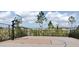 Community basketball court surrounded by a chain link fence and manicured bushes at 2880 Gumbo Limbo Dr, Wimauma, FL 33598
