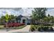 Exterior view of a charming clubhouse with manicured landscaping and colorful plants at 2880 Gumbo Limbo Dr, Wimauma, FL 33598