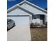 Charming single-story home with a two-car garage and stone accents under a blue sky at 2880 Gumbo Limbo Dr, Wimauma, FL 33598