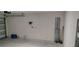 Garage showcasing an open interior with a garage door, concrete floor and storage on the side at 2880 Gumbo Limbo Dr, Wimauma, FL 33598