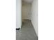 Hallway with neutral paint, baseboard trim, tile flooring, and a white door at 2880 Gumbo Limbo Dr, Wimauma, FL 33598