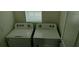 Laundry room featuring a window, two Whirlpool washing machines, and neutral paint at 2880 Gumbo Limbo Dr, Wimauma, FL 33598