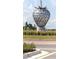 Community art displayed as a modern steel strawberry sculpture on manicured grounds at 2880 Gumbo Limbo Dr, Wimauma, FL 33598