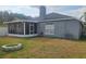 Backyard featuring a screened-in patio, gray home exterior, and a fire pit at 29228 Yarrow Dr, Wesley Chapel, FL 33543
