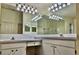 Bathroom featuring double sinks, vanity cabinets, and large mirror with decorative lighting at 29228 Yarrow Dr, Wesley Chapel, FL 33543
