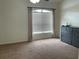 Bedroom featuring neutral walls, carpeted floors and a window with blinds and curtains at 29228 Yarrow Dr, Wesley Chapel, FL 33543