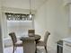 Cozy dining area with a round table, four upholstered chairs, and a decorative light fixture at 29228 Yarrow Dr, Wesley Chapel, FL 33543