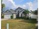 Charming single-story home with a well-manicured lawn and beautiful landscaping under a bright, cloudy sky at 29228 Yarrow Dr, Wesley Chapel, FL 33543