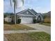 Charming home with a two-car garage, brick accents, and well-maintained landscaping at 29228 Yarrow Dr, Wesley Chapel, FL 33543