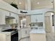 Bright, spacious kitchen with white cabinets, island, stone backsplash, and stainless steel appliances at 29228 Yarrow Dr, Wesley Chapel, FL 33543