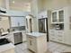 Modern kitchen with stainless steel appliances, island with quartz countertop, and white cabinets at 29228 Yarrow Dr, Wesley Chapel, FL 33543