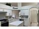 Bright, spacious kitchen with white cabinets, island, stone backsplash, and stainless steel appliances at 29228 Yarrow Dr, Wesley Chapel, FL 33543
