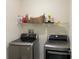 Well-lit laundry room featuring a modern, side-by-side washer and dryer and wire shelving at 29228 Yarrow Dr, Wesley Chapel, FL 33543