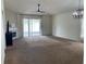 Open living room with ceiling fan, fireplace and sliding glass doors leading to the patio at 29228 Yarrow Dr, Wesley Chapel, FL 33543