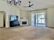 Open living room with fireplace, ceiling fan and sliding glass doors leading to the patio at 29228 Yarrow Dr, Wesley Chapel, FL 33543