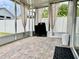 Enclosed sunroom with tile flooring, white panel fencing, and a grill at 29228 Yarrow Dr, Wesley Chapel, FL 33543