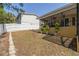 A spacious backyard with a white fence providing privacy, complemented by potted plants and a covered porch at 315 Ridge Rd, Palm Harbor, FL 34683