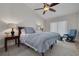 Comfortable bedroom featuring a bed, ceiling fan, side tables with lamps, chair and carpet at 315 Ridge Rd, Palm Harbor, FL 34683