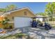 Charming home featuring a two-car garage and an upgraded golf cart parked on driveway at 315 Ridge Rd, Palm Harbor, FL 34683