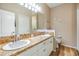 Bathroom featuring double sinks with granite counters and wooden floors at 3205 Audubon Ct, Tarpon Springs, FL 34688