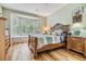 Cozy bedroom featuring a comfortable bed, natural lighting from a large bay window, and wood floors at 3205 Audubon Ct, Tarpon Springs, FL 34688