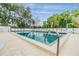 Community pool with plenty of seating and views of surrounding greenery and palm trees at 3205 Audubon Ct, Tarpon Springs, FL 34688