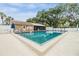 Community pool with lounge chairs, lush landscaping, and community building at 3205 Audubon Ct, Tarpon Springs, FL 34688