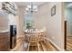 Cozy dining nook featuring a chandelier, window with blinds, and a table set for four, located off the kitchen at 3205 Audubon Ct, Tarpon Springs, FL 34688