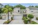Beautiful two-story townhome with a two-car garage, green shutters, and lush landscaping at 3205 Audubon Ct, Tarpon Springs, FL 34688