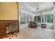 Enclosed sunroom with a desk area and relaxing chair with views of the backyard trees at 3205 Audubon Ct, Tarpon Springs, FL 34688