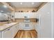 Bright kitchen with white cabinets, countertops, and wood-look flooring, providing a clean and modern cooking space at 3205 Audubon Ct, Tarpon Springs, FL 34688