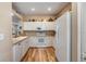 Bright kitchen with white cabinets, countertops, and wood-look flooring, providing a clean and modern cooking space at 3205 Audubon Ct, Tarpon Springs, FL 34688