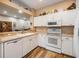 Bright kitchen with white cabinets, countertops, and wood-look flooring, providing a clean and modern cooking space at 3205 Audubon Ct, Tarpon Springs, FL 34688