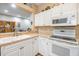 Bright kitchen with white cabinets, countertops, and wood-look flooring, providing a clean and modern cooking space at 3205 Audubon Ct, Tarpon Springs, FL 34688
