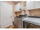 Convenient laundry room with modern washer and dryer, plus ample storage cabinets at 3205 Audubon Ct, Tarpon Springs, FL 34688