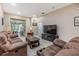Cozy living room features comfortable sofa seating and access to Florida room at 3205 Audubon Ct, Tarpon Springs, FL 34688
