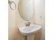 Powder room featuring pedestal sink, oval mirror, and neutral wallpaper at 3205 Audubon Ct, Tarpon Springs, FL 34688