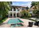 Backyard with an inground pool, lush landscaping, brick paver patio, and a two-story home at 3212 W Fountain Blvd, Tampa, FL 33609