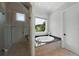 Bathroom featuring soaking tub with granite surround, glass shower, and natural light at 3212 W Fountain Blvd, Tampa, FL 33609
