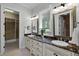Bathroom with double vanity, granite countertops, large mirrors, and access to walk-in closet at 3212 W Fountain Blvd, Tampa, FL 33609