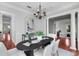 Elegant dining room with black table, white chairs, modern chandelier, and adjacent living areas at 3212 W Fountain Blvd, Tampa, FL 33609