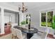 Dining room featuring a black oval table, white chairs, and views of the landscaped yard at 3212 W Fountain Blvd, Tampa, FL 33609