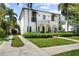Stunning exterior view showcasing a white stucco home with well-manicured lawn, private drive and lush greenery at 3212 W Fountain Blvd, Tampa, FL 33609