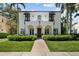 Beautiful white stucco two-story home with arched porch, tile roof, lush landscaping and brick walkway at 3212 W Fountain Blvd, Tampa, FL 33609