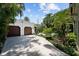 Detached two-car garage with lush landscaping, a view of the pool, and a sunny sky at 3212 W Fountain Blvd, Tampa, FL 33609